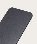 A close-up of the Gather 1x4 Base Plate (Black), a rectangular, matte black steel panel with a textured powder-coated finish and rounded corners, shown against a plain, light background.
