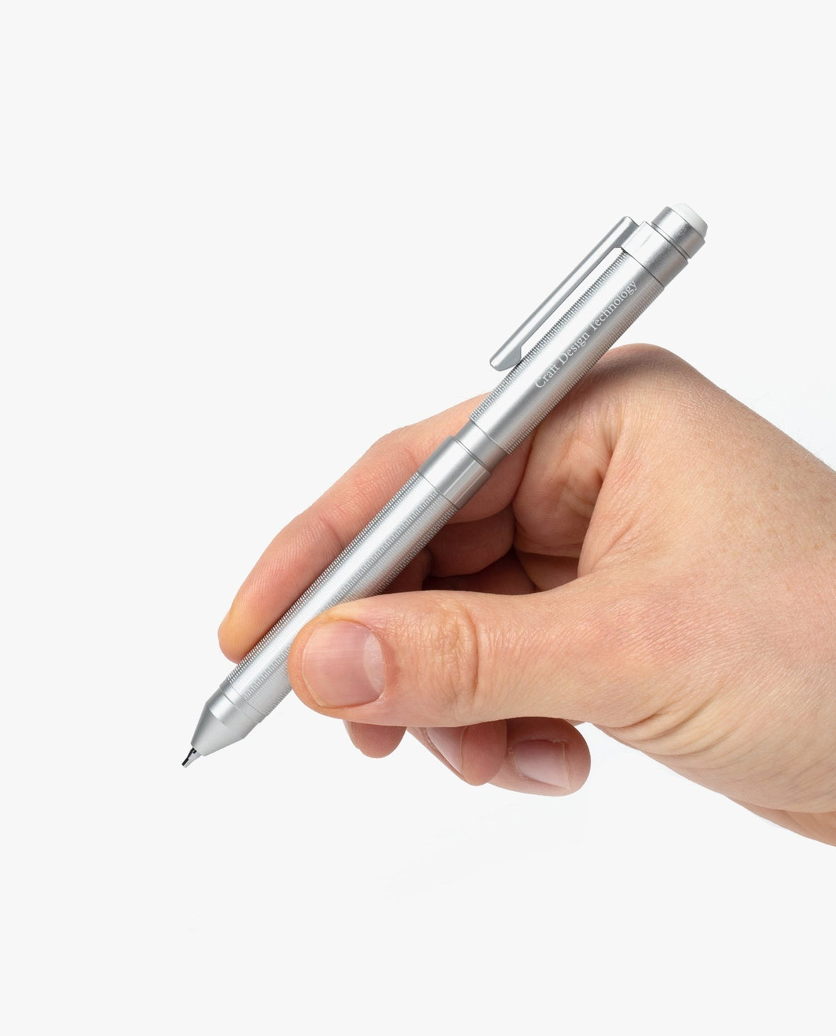 A hand holding the Craft Design Technology Multifunctional Pen, featuring a sleek silver design, against a plain white background.