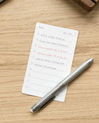 The Craft Design Technology Multifunctional Pen rests on a wooden desk next to a to-do list with tasks like editing web photos, publishing a new product, calling Laura at 2:00 pm, meeting Jason at 3:30 pm, and ordering packaging.