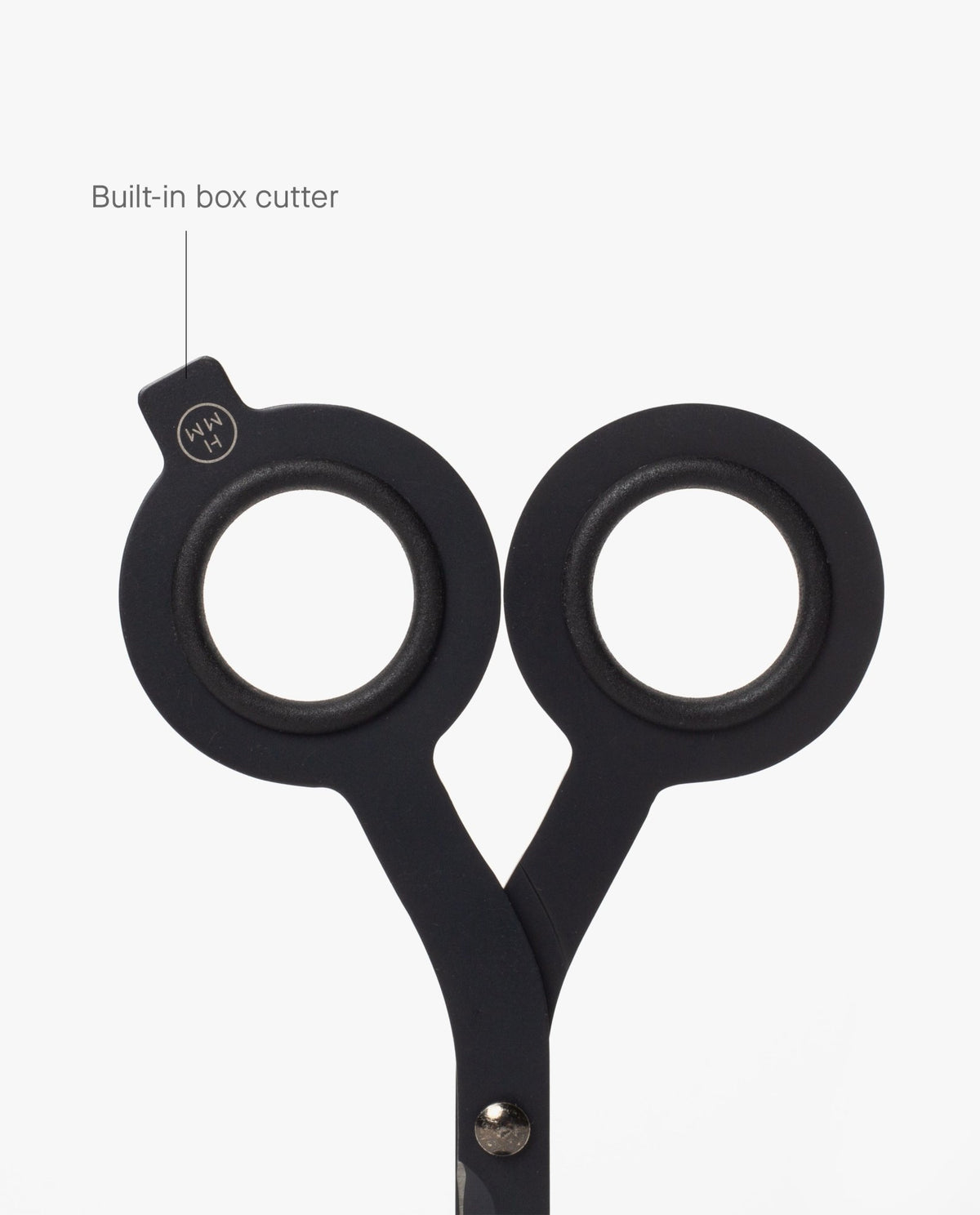 A close-up of HMM Scissors (Black) showcases their round handles, with one handle featuring a labeled built-in box cutter extending from the edge, all set against a white background.