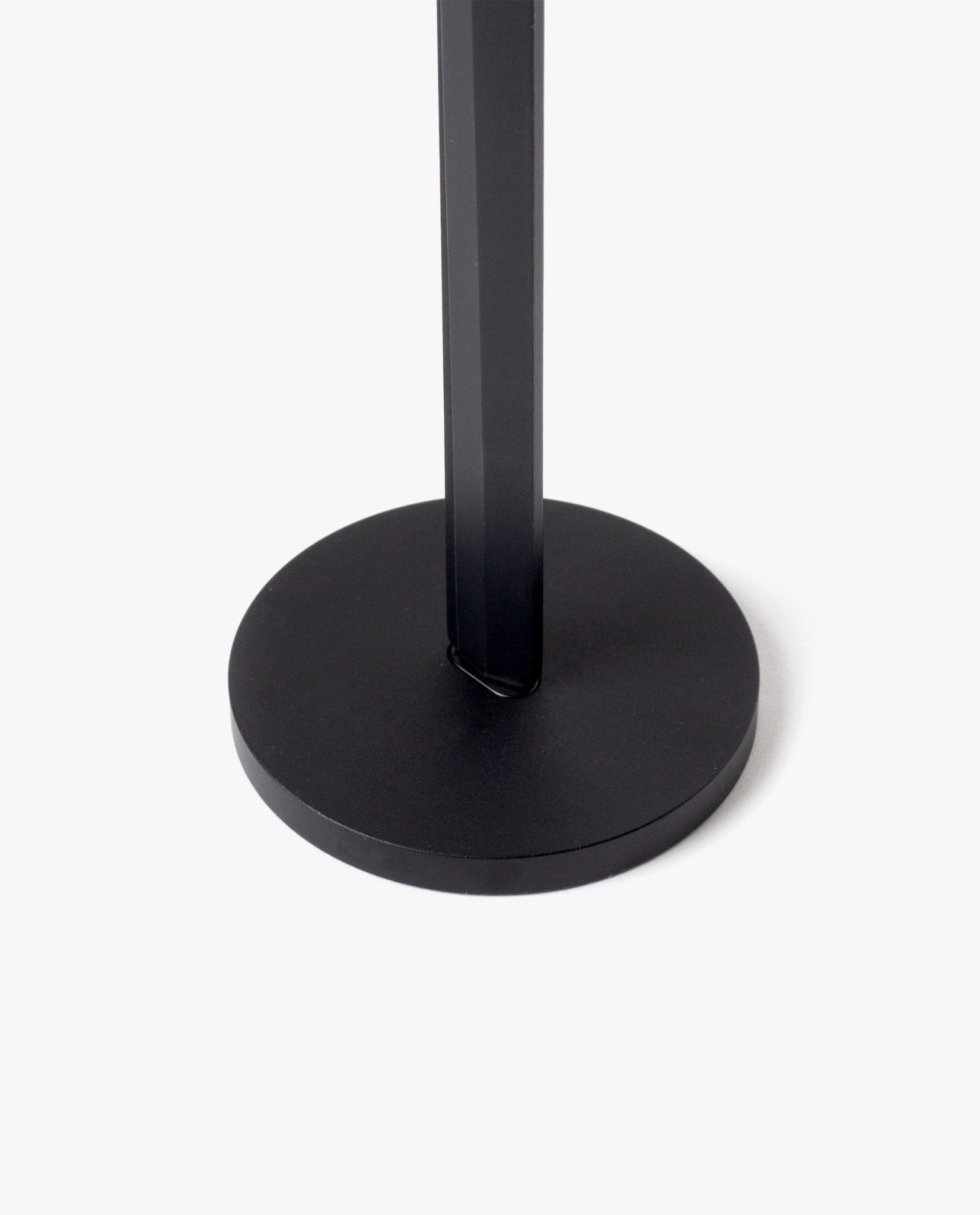 A close-up of the HMM Scissors (Black) shows its black, round magnetic metal base with a vertical pole at the center, set against a plain white background.
