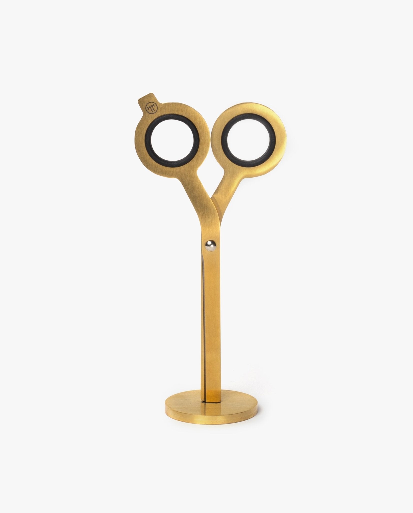 A pair of modern HMM Scissors (Gold) with circular handles stands upright on a matching gold base against a white background.