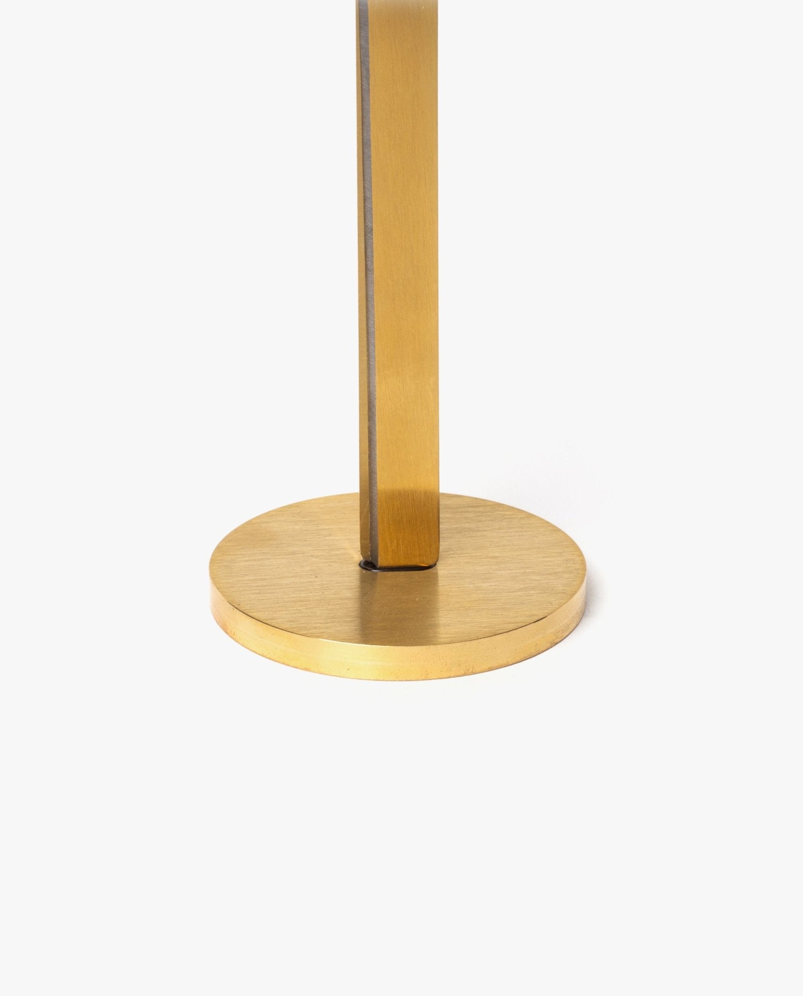 Close-up of the base and lower stem of a gold-colored metal object, possibly a lamp or stand, on a plain white background—evoking the refined elegance of the HMM Scissors (Gold).