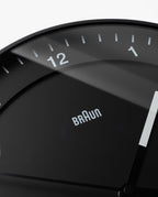 Close-up of the Braun Wall Clock (Black), featuring an easy-to-read minimalist design with white hands and bold numbers 11, 12, and 1.