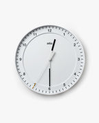 The Braun Wall Clock (White) is a round analog wall clock displaying the time as 12:30:35. The word "Braun" appears below the 12. It features an easy-to-read dial with black hour and minute hands, as well as a thin white silent sweeping second hand tipped in yellow.