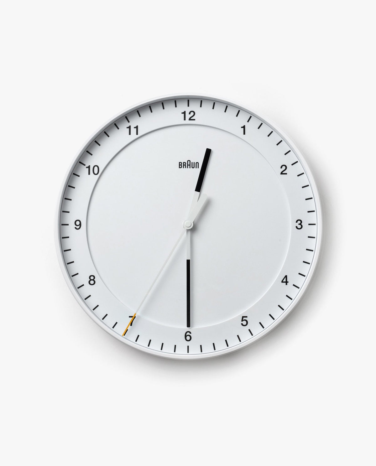 The Braun Wall Clock (White) is a round analog wall clock displaying the time as 12:30:35. The word "Braun" appears below the 12. It features an easy-to-read dial with black hour and minute hands, as well as a thin white silent sweeping second hand tipped in yellow.