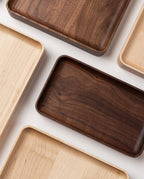 A Valet Tray (Walnut - Small), handcrafted in Pennsylvania, is displayed on a white surface. It features smooth edges and showcases the natural walnut wood grain.