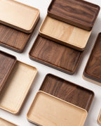 Several Valet Tray (Maple - Medium) pieces are arranged in a grid on a white surface, highlighting their smooth finishes, visible natural wood grain, and expert handcrafted quality.