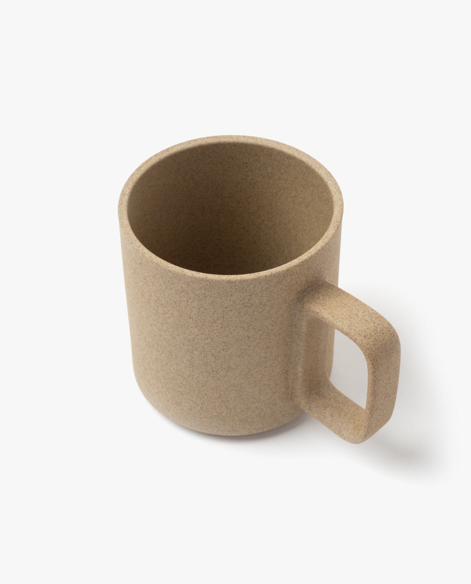 A Hasami Porcelain Mug (Natural) in beige with a textured ceramic finish, featuring a large, square-shaped handle inspired by Japanese ceramics, displayed on a plain white background.