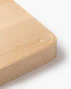 A close-up of the Valet Tray (Maple - Medium) corner shows a single water droplet resting on its smooth, handcrafted maple surface. Set against a plain white background, it highlights the tray's quality as a decorative or organizational accent.