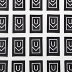 Multiple Ugmonk Patches—black rectangular embroidered patches featuring a bold white geometric U-shaped design—are arranged in neat rows on a white background.