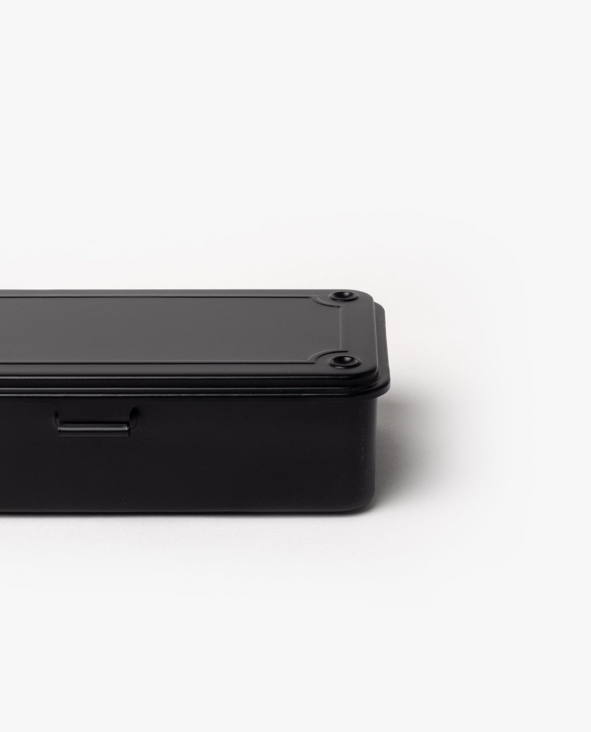 Partially shown against a plain white background, the Toyo Steel Stackable Storage Box T-190 (Black) features a black rectangular metal design with rounded edges and visible screws on the lid, highlighting its classic stackable toolbox style.