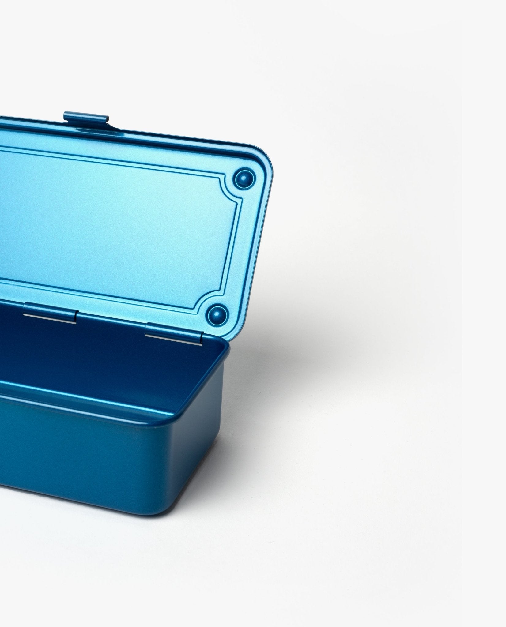 A Toyo Steel Stackable Storage Box T-190 in blue, made in Japan, is displayed against a plain white background with its lid partially open. Only the left side of this metal storage box is visible.