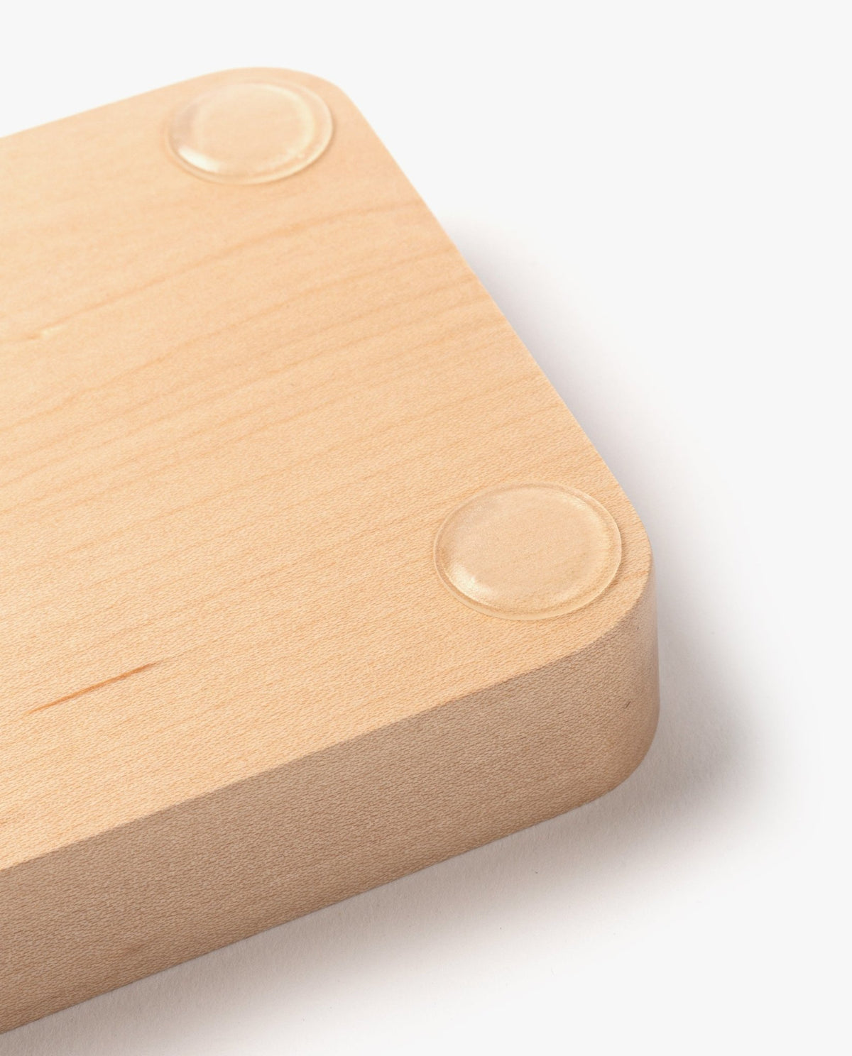 A close-up of the Valet Tray (Maple - Small), a handcrafted solid maple wooden block with rounded edges and two clear rubber pads on the bottom, designed in a minimalist style and displayed on a white background.