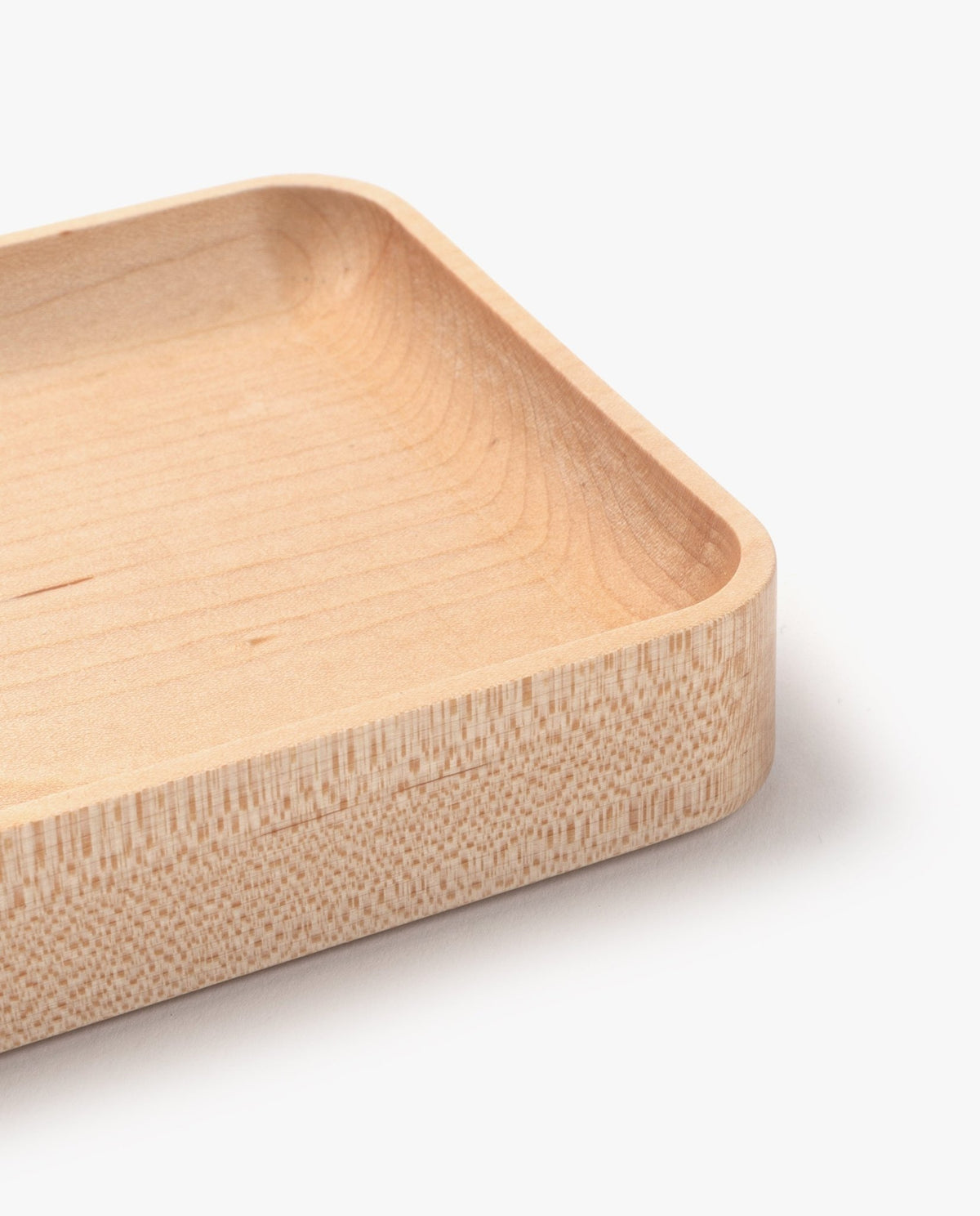 A close-up view of the corner of the Valet Tray (Maple - Small) highlights its handcrafted rectangular design with rounded edges, showcasing the smooth, light-colored maple wood grain and precise craftsmanship against a white background.